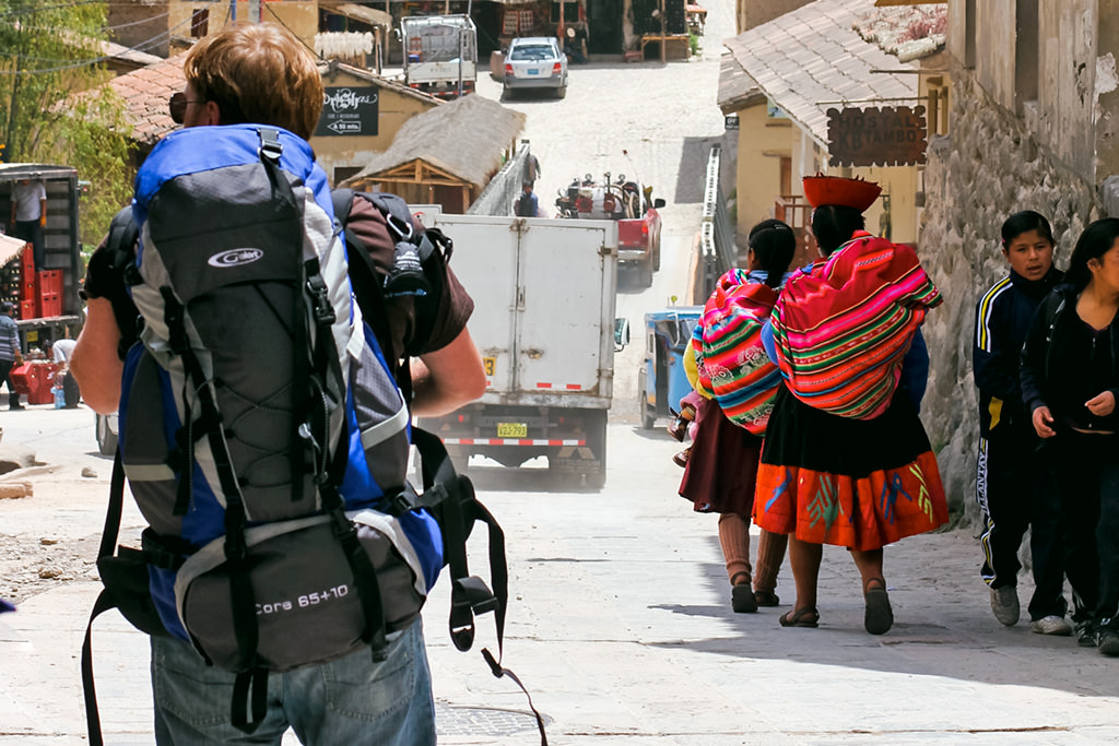 Traveler walkign down a crowded urban street with a 55L backpack, best backpack for south america