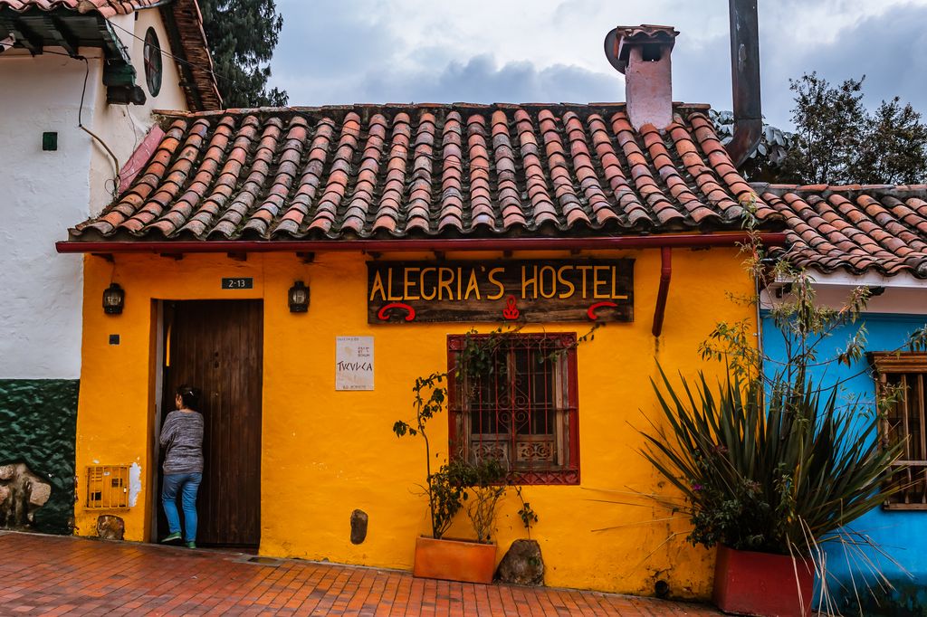 The outside of a hostel with yellow painted walls in La Candelaria, Bogota, Colombia.