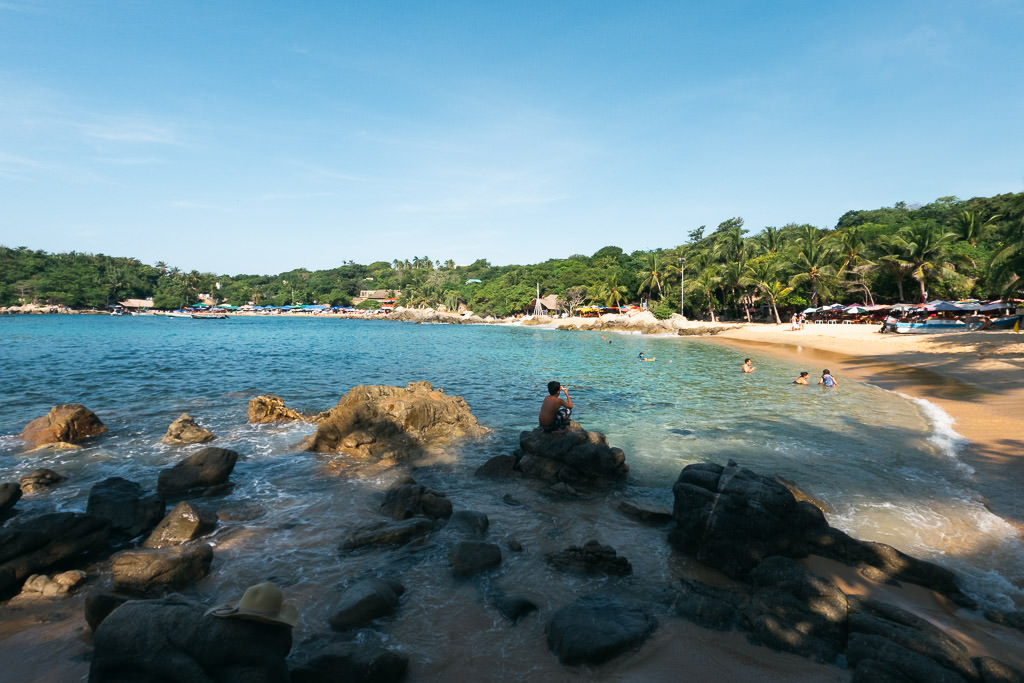 A view of Manzanillo Beach in Oaxaca, Mexico, under a clear blue sky