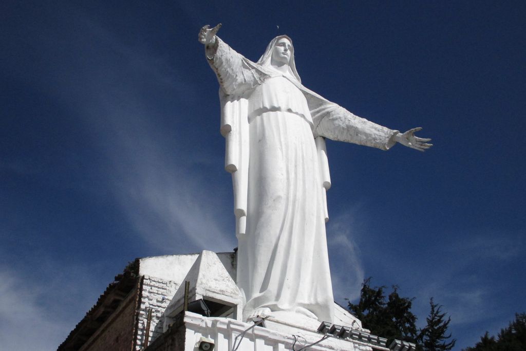 A giant, white status of a person spreading their arms wide open.