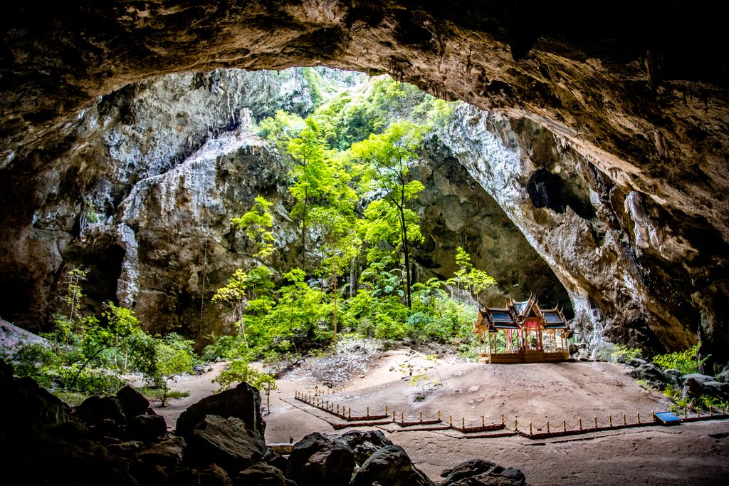A cave with an opening with a small royal pavilion in Thailand.